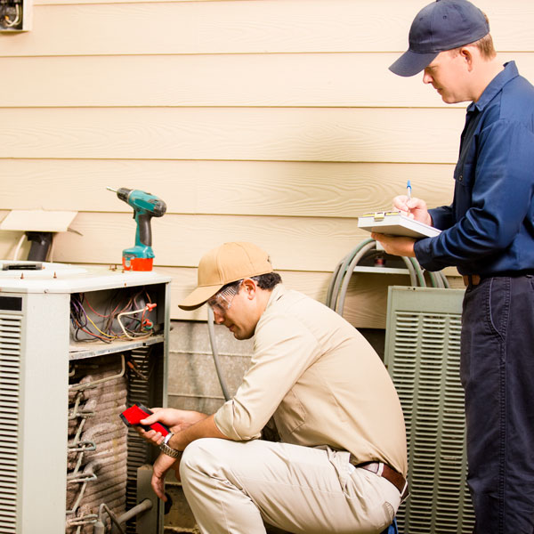 two technicians inspecting HVAC unit