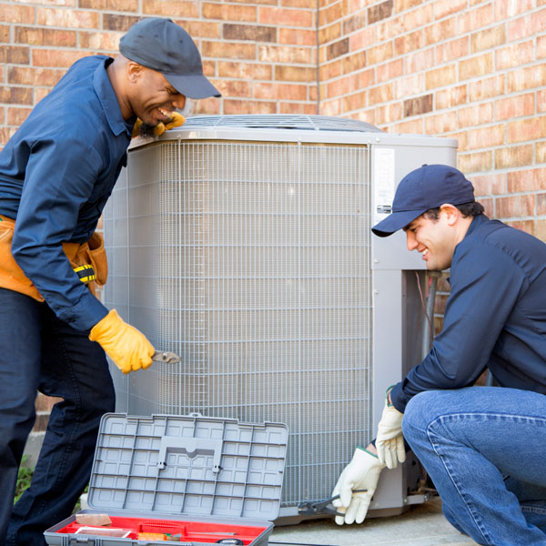 two technicians repairing HVAC unit