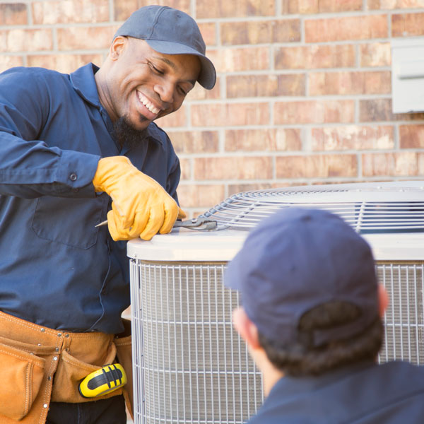 smiling technician repairing HVAC unit